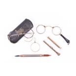 A small collection of propelling pencils and eye glasses comprising a 9 carat gold empty