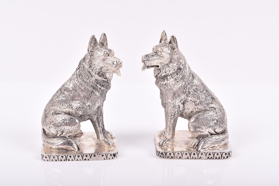 A pair of novelty white metal salt and pepper shakers in the form of seated German Shepherd dogs,