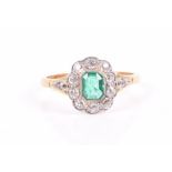 An 18ct yellow gold, diamond, and emerald cluster ring set with an emerald-cut emerald surrounded