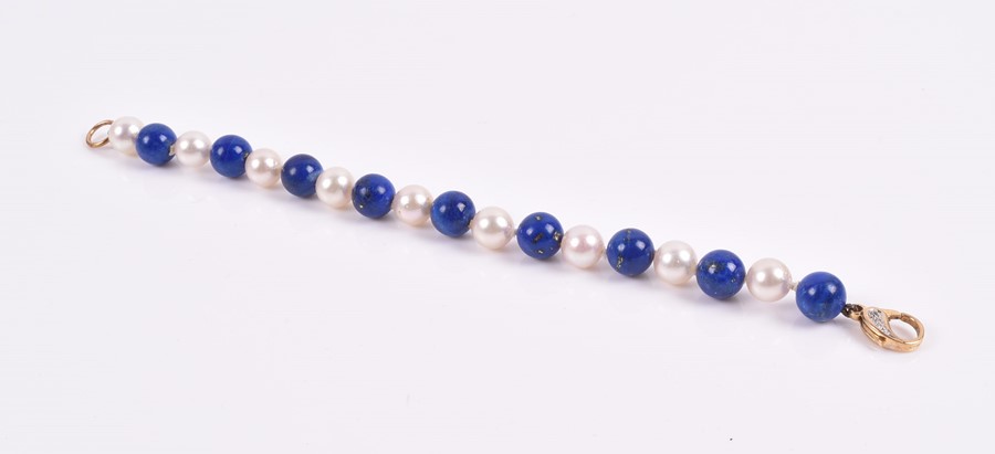 A lapis lazuli and pearl bracelet of alternated beads, fastened with an 18ct yellow gold and