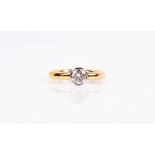 An 18ct yellow gold and solitaire diamond ring the round-cut diamond rubover set in a white gold