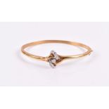 A yellow gold and diamond bangle set with a white gold stylised knot set with diamonds, the