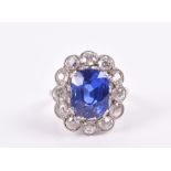 A sapphire and diamond cluster ring set with a fine cornflower blue, cushion-cut natural sapphire,