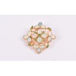 A yellow metal, opal, and demantoid garnet pendant / brooch of quatrefoil design, the open mount