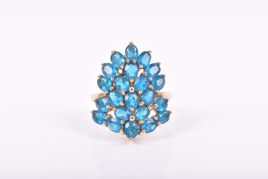 A 9ct yellow gold and peacock apatite ring set with a stylised cluster of mixed oval-cut blue