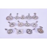 A collection of thirteen Dutch silver tea strainers each decorated with pierced scroll borders, some