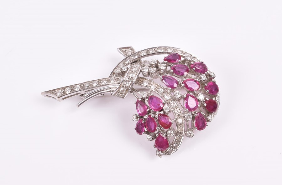 An 18ct white, diamond, and ruby brooch in a floral bouquet, set with pear-cut rubies and round