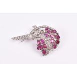 An 18ct white, diamond, and ruby brooch in a floral bouquet, set with pear-cut rubies and round