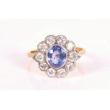 An 18ct yellow gold, diamond, and sapphire cluster ring set with a mixed oval-cut sapphire of