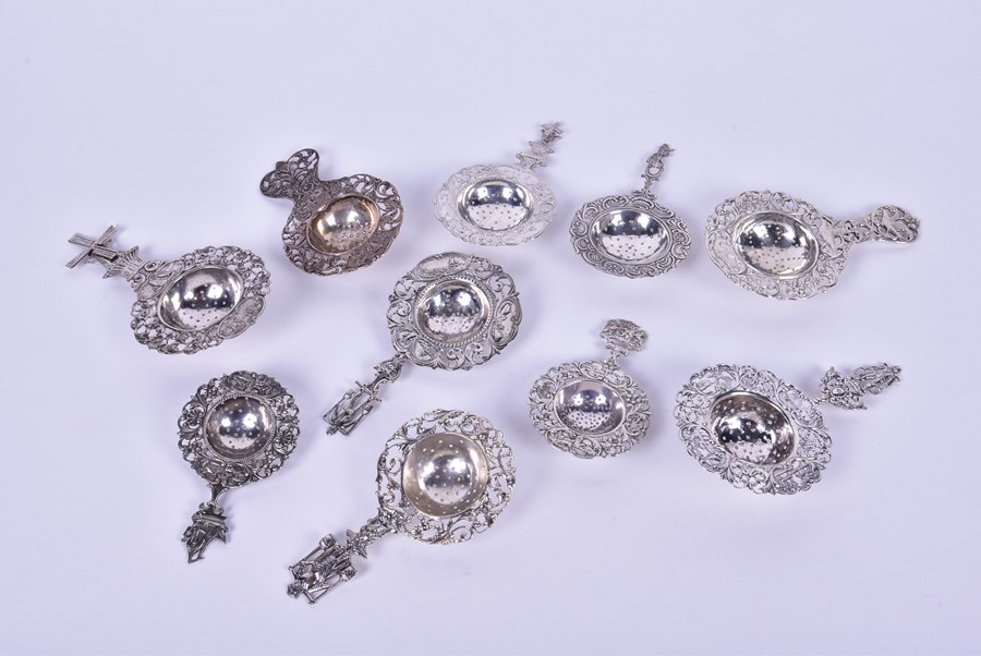 A collection of ten 20th century Dutch tea strainers each with pierced floral rims with pastoral