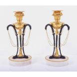 A pair of French Empire style ormolu mounted candlesticks with central patinated bronze triform