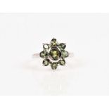 A 9ct white gold and green sapphire cluster ring set with an oval cluster, size N.