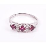 An 18ct white gold, diamond, and ruby ring set with three square-cut rubies and four round-cut