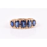 An 18ct yellow gold and sapphire ring set with five graduated oval-cut sapphire interspersed with