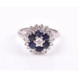 An 18ct white gold, diamond, and sapphire cluster ring the stepped cluster centred with a round-