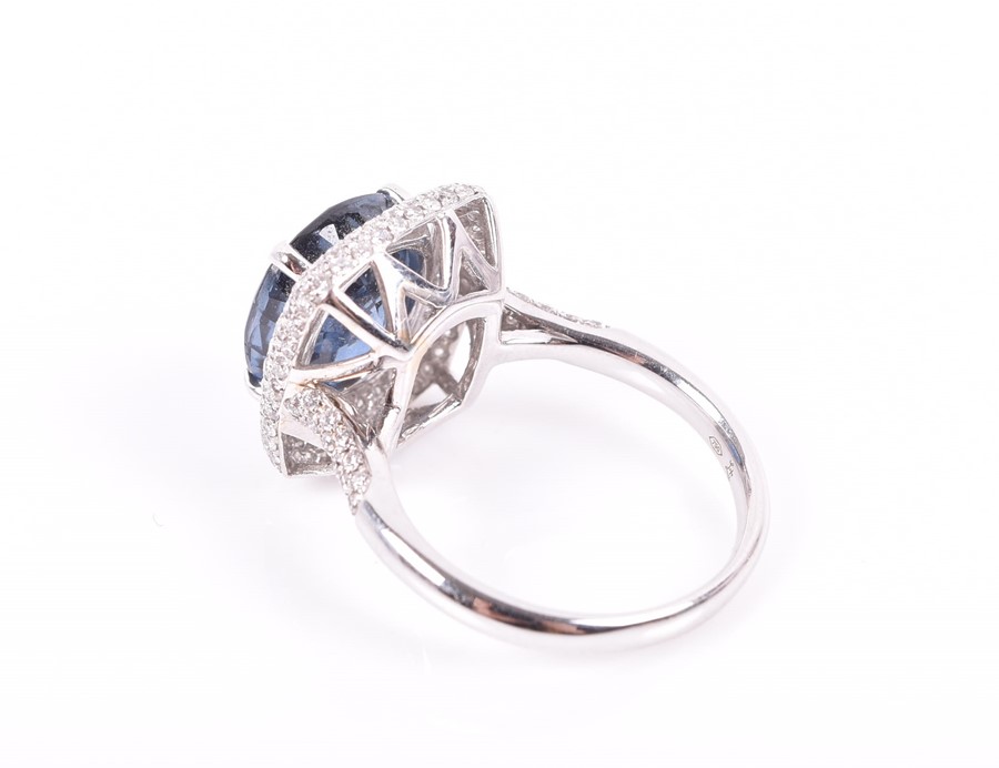 An 18ct white gold, diamond, and sapphire ring set with a cushion-cut blue sapphire of approximately - Image 2 of 3