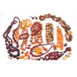 A group of various amber beaded necklaces including some amberlite, a silver and amber brooch, a