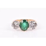 An 18ct yellow gold, diamond, and emerald ring set with an oval-cut emerald of approximately 1.50