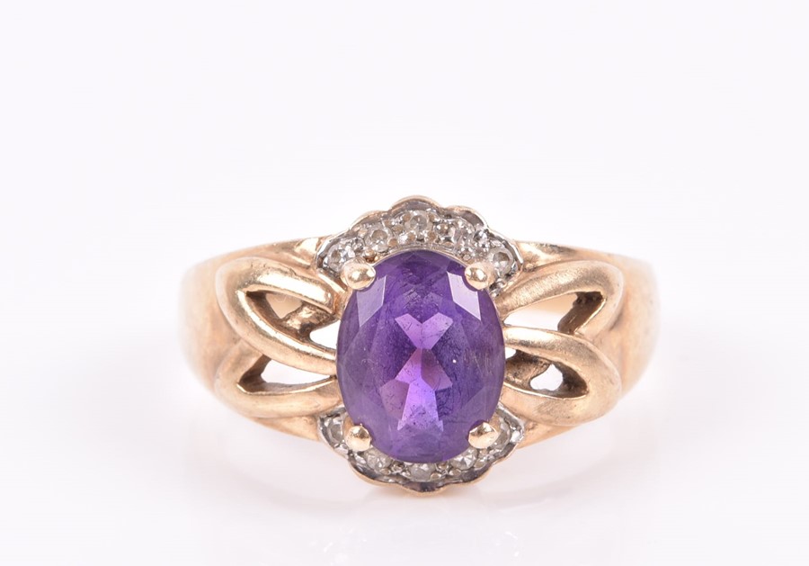 A 9ct yellow gold, diamond, and amethyst ring set with a mixed oval-cut amethyst with openwork