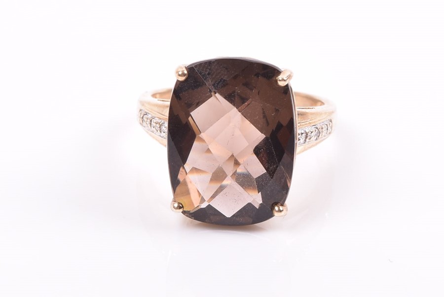 A 9ct yellow gold and smoky quartz ring set with a top-faceted rectangular-cut quartz, the shoulders