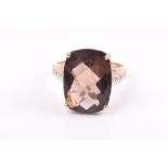 A 9ct yellow gold and smoky quartz ring set with a top-faceted rectangular-cut quartz, the shoulders