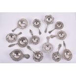 A collection of thirteen Dutch silver tea strainers each floral themed with pierced foliage border