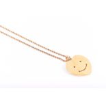 Theo Fennell. An 18ct yellow gold heart-shaped pendant with smiley face, suspended on a rope-twist