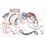 A group of various multi-coloured cultured pearl necklaces including red, blue, black, green, and