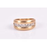 An 18ct yellow gold and diamond band ring the wide, matte-finished band centred with a calibre-set