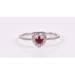 An 18ct white gold, diamond, and ruby ring the petite heart-shaped mount centred with a round-cut