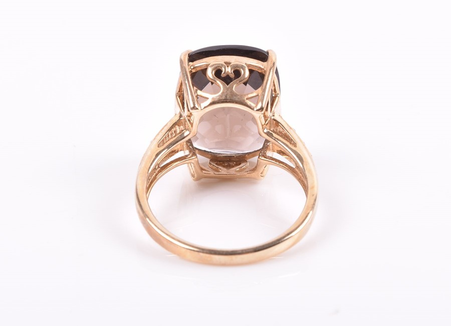 A 9ct yellow gold and smoky quartz ring set with a top-faceted rectangular-cut quartz, the shoulders - Image 2 of 3