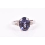 A 9ct white gold, iolite, and diamond ring set with an oval-cut iolite, with triangular diamond