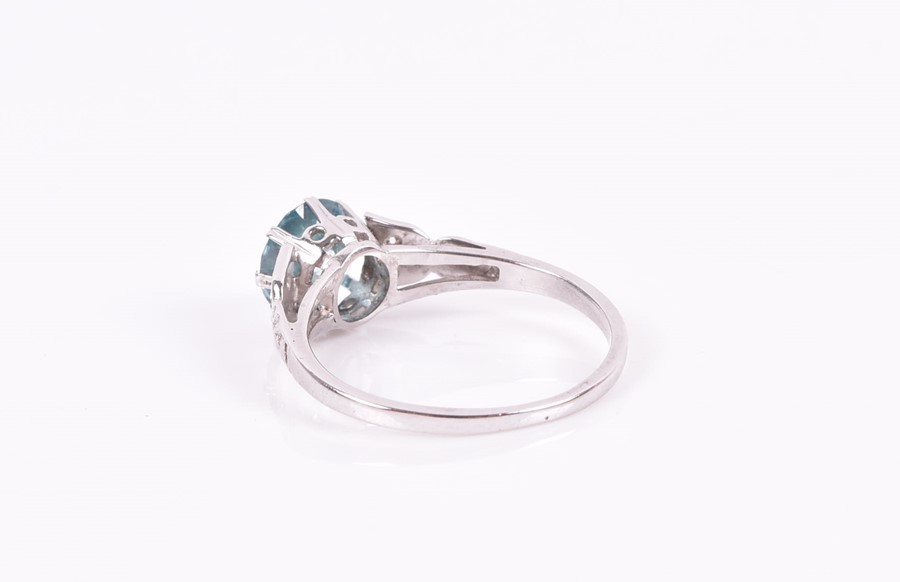 A 9ct white gold, blue zircon, and diamond ring set with a round-cut natural zircon, the shoulders - Image 2 of 2