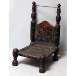 Traditioneller, niedriger Stuhl. Gedrechseltes, dunkles Holz mit Ornamentkerbschnitzerei,