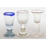 Drei Gläser. Farblos. Einmal mit aufgeschmolzenem, weißen Milchglasrand bzw. hellblau mit