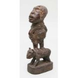 Afrikanische Skulptur,auf einem Tier stehend. Holz/Ton/Stoff/Metall. Trockenrisse, l. best. H. 30