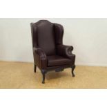 An ear chair with burgundy leather upholstery Oorfauteuil bekleed met boreaurood leer