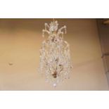 A yellow metal three-light chandelier Geel metalen 3-lichts hangkroon met pegels