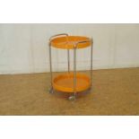 Theetrolley met oranje kunststoffen etagere, jaren 60, h. 62, diam. 42 cm. Theetrolly with orange