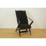 Een zwarte vouwstoel met koperen knoppen, bekleed met zwart velours a black folding chairs with
