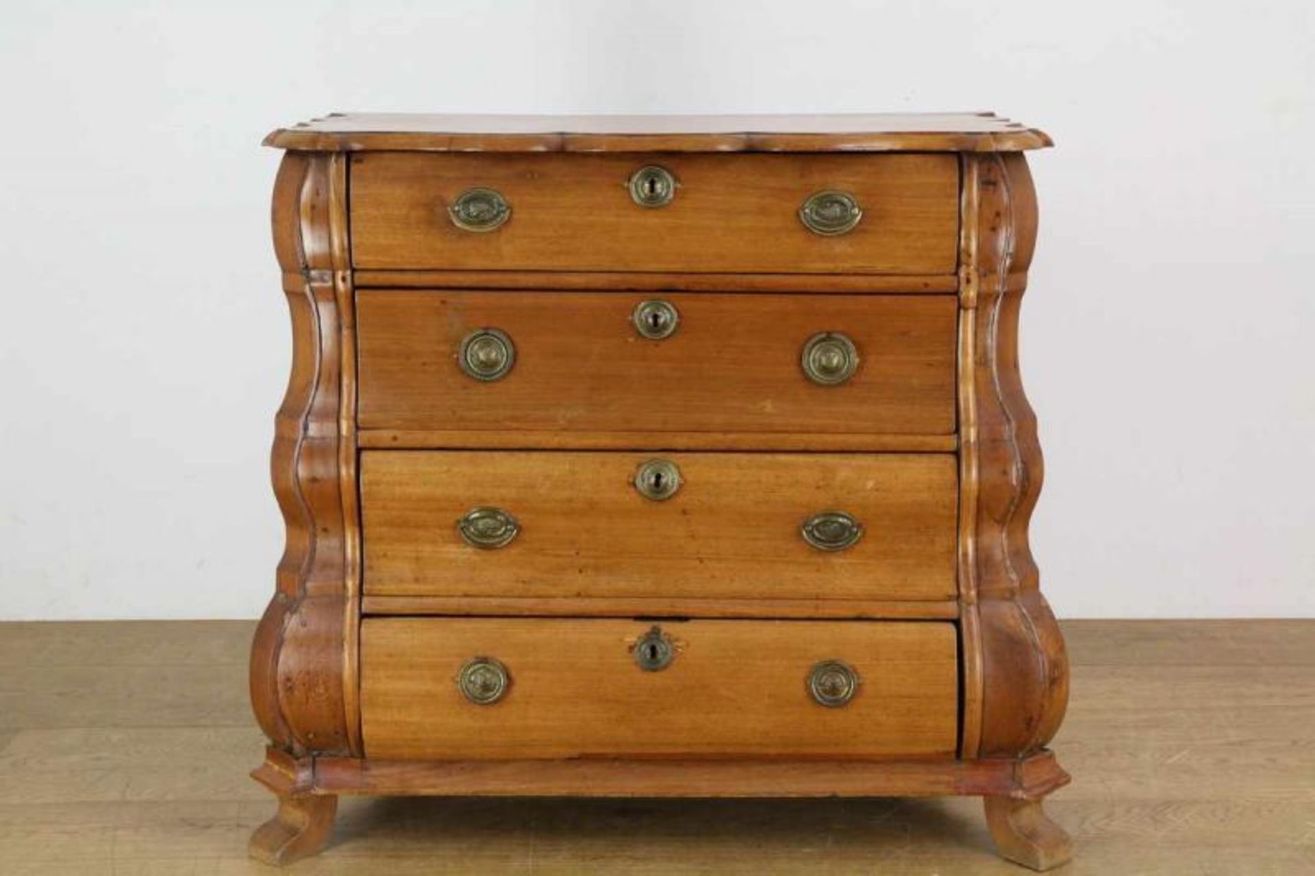 Mahoniehouten commode, 19e eeuw, met gecontourneerd blad. In het gebogen front vier laden br. 87, h.