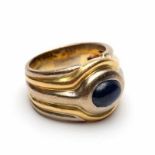 Wit- en geelgouden ring in het midden gezet met een ovale cabochon geslepen saffier bruto 13,1 gr.