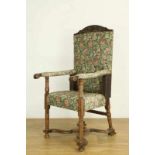 Notenhouten fauteuil, deels 18e eeuw, met gebloemde stoffering. De samengestelde constructie met