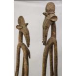 Senufo, paar grote staande gestoken houten sculpturen; uitgestrekte figuren met handen op de
