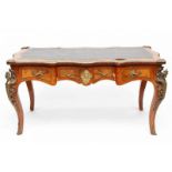 Notenhouten bureau-plat in Louis XV-stijl. Het gecontourneerde blad ingelegd met bruin kunstleder.