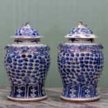 China, paar blauw wit porseleinen dekselvazen, 19e eeuw,met ringen langs de hals en leeuwen als knop