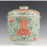 China, porseleinen Wuacai dekspot, 18e eeuw,met groen-rood-geel vol bloesemdecor h. 23, diam. 22 cm.