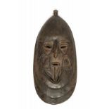 PNG, Madang Province, wooden maskwith geometrical designs, open septum and two carved oval shapes.