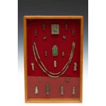 Egypte, collection of amulets in display cabinet, also Late Period,one amulet with three gods,