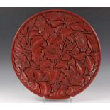 China, rood lakwerk (of kunststof?) bord, 20e eeuw,met reliëf van bloemen. De achterzijde zwart
